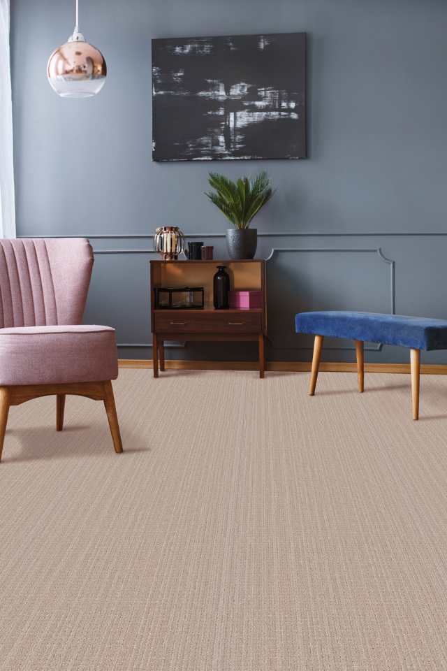 beige patterned carpet in mid century living room with blue wall and velvet furniture